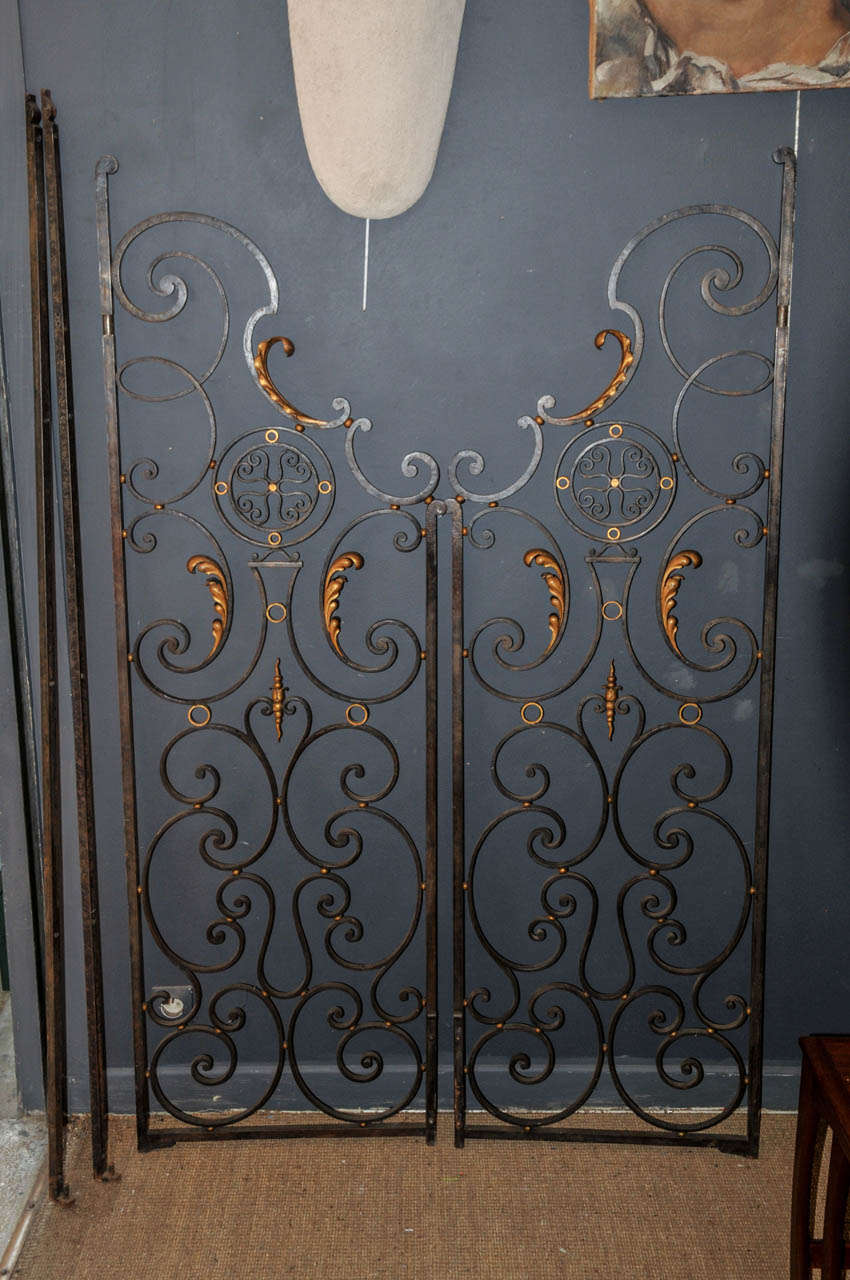 Pair of 1940's decorative doors. Wrought iron and gilded iron. With the fixtures. Good condition. Normal wear consistent with age and use.

Dimension for each door: Height 180cm - Width 57cm - Depth 4cm