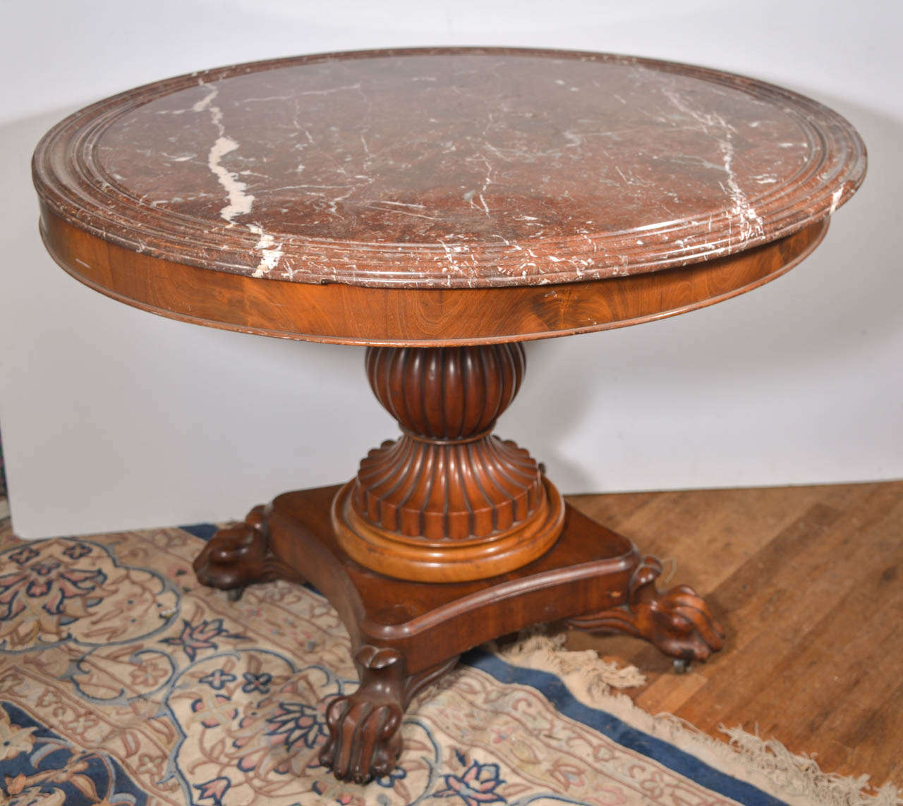 A Louis Philippe marble-top center table
Belgium, mid-19th century.
A fantastic marble top mahogany center table. Superb quality shown in the bulbous and reeded column to the flamed mahogany platform and resting on meticulous claw feet with hidden