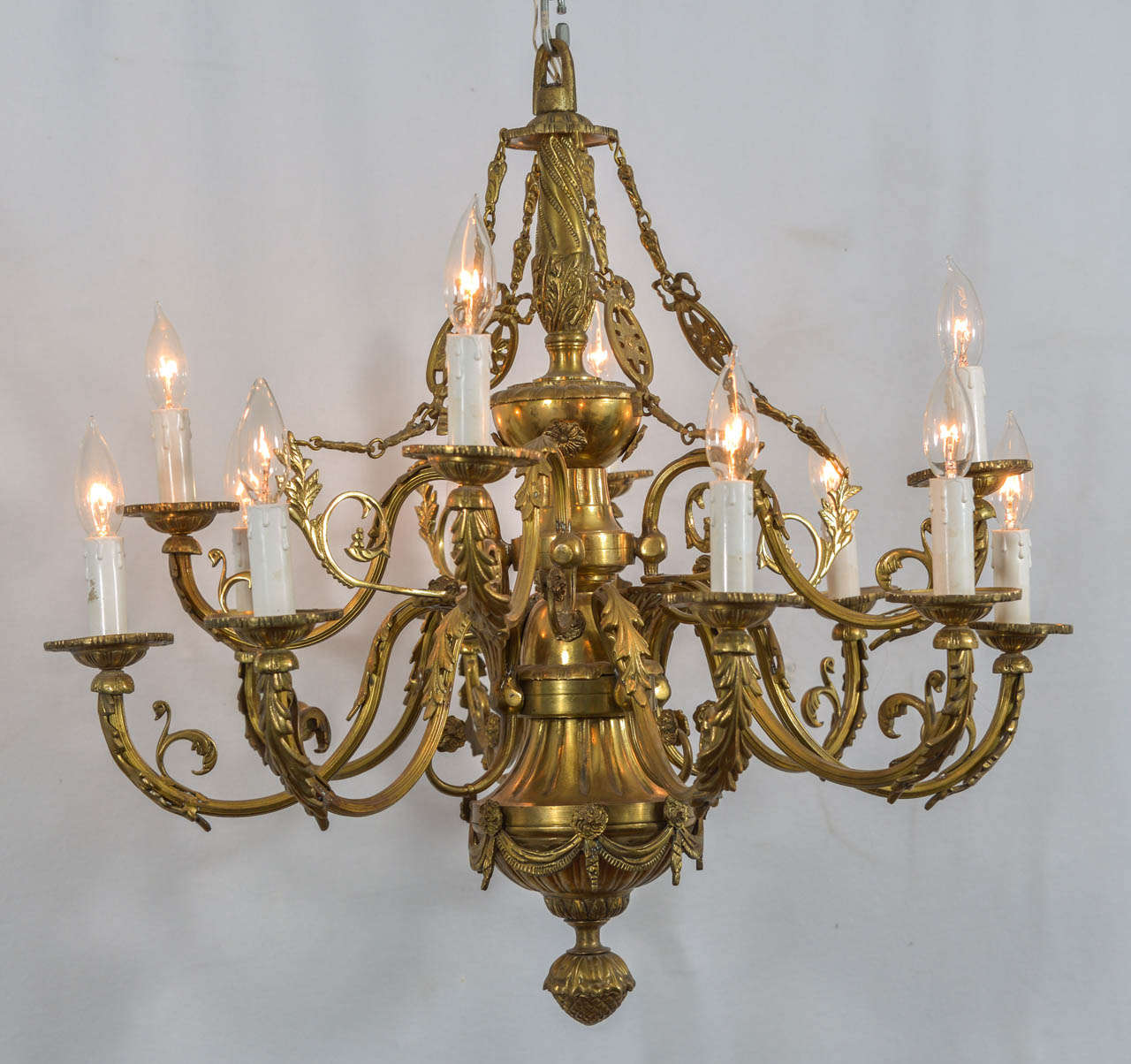 Cast Bronze, 12 Light Chandelier in the style of Louie XVI, with beautiful swags, leaves, and curling arms.