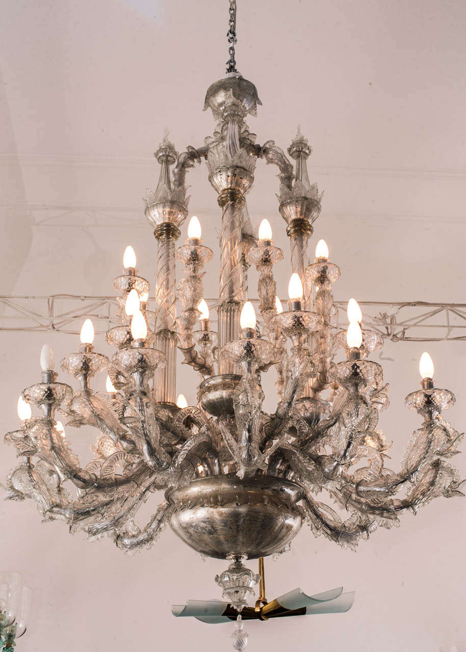 Big chandelier in transparent blown glass.
24 lights. Dolphin-shaped arms and four columns in the centre.
Murano, 1920's.