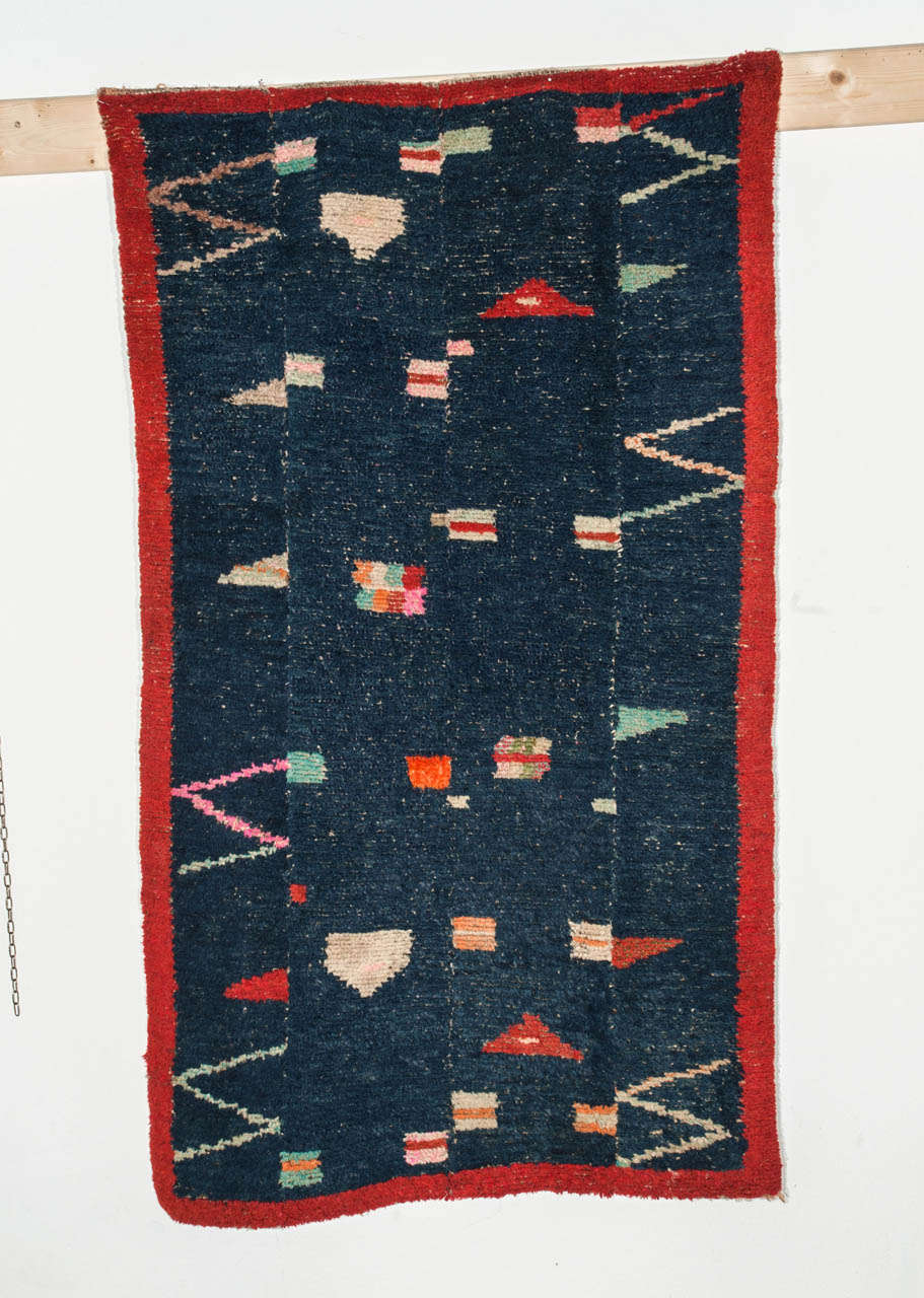 Rugs woven in this particular type of cut-loop technique follow a tradition which dates to the earliest forms of pile weaving. Each of the four panels is woven individually and are then are hand-stitched together. The handle of tsukdruk rugs is