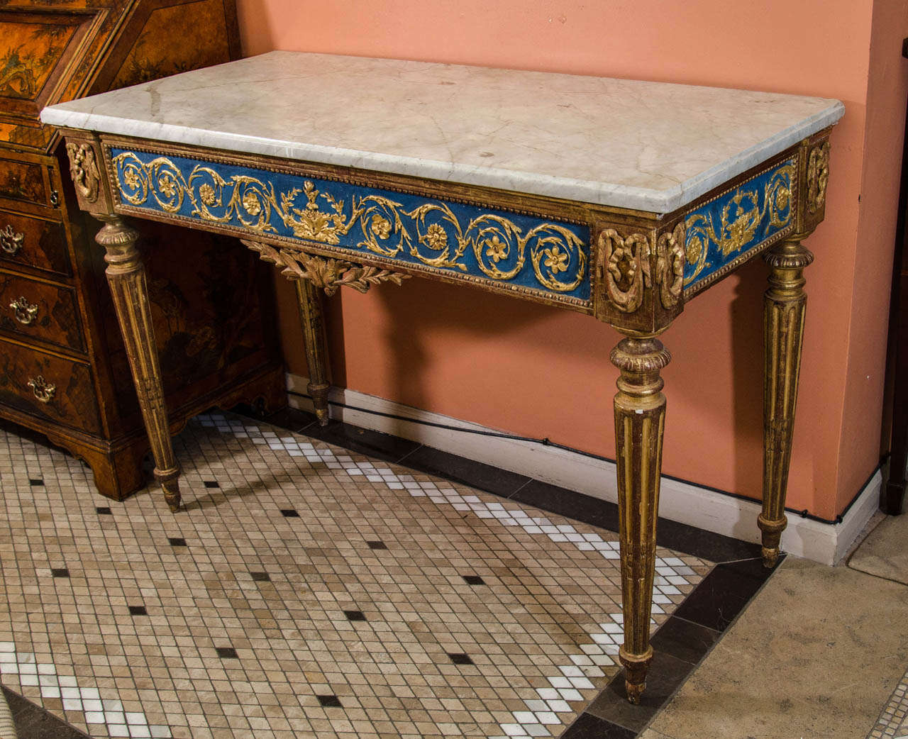 A fine Italian Louis XVI marble top painted and gilded console table with carved drapery and fluted legs.