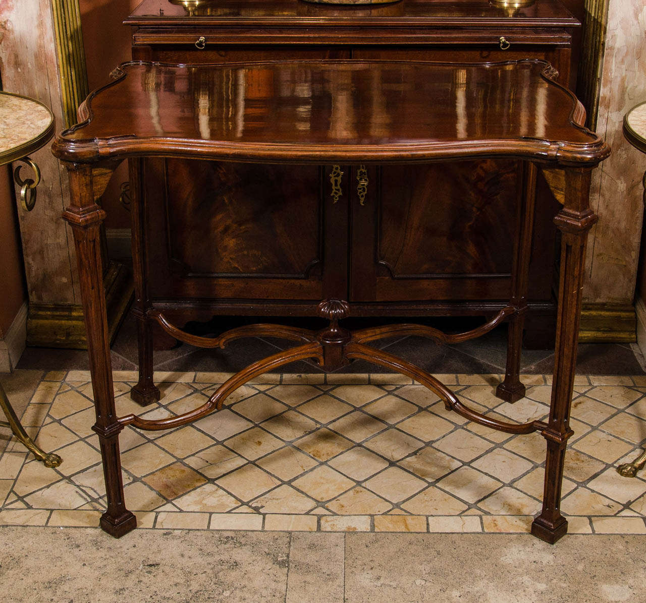 An unusual George II mahogany serpentine silver table with marlboro feet and stretcher base.