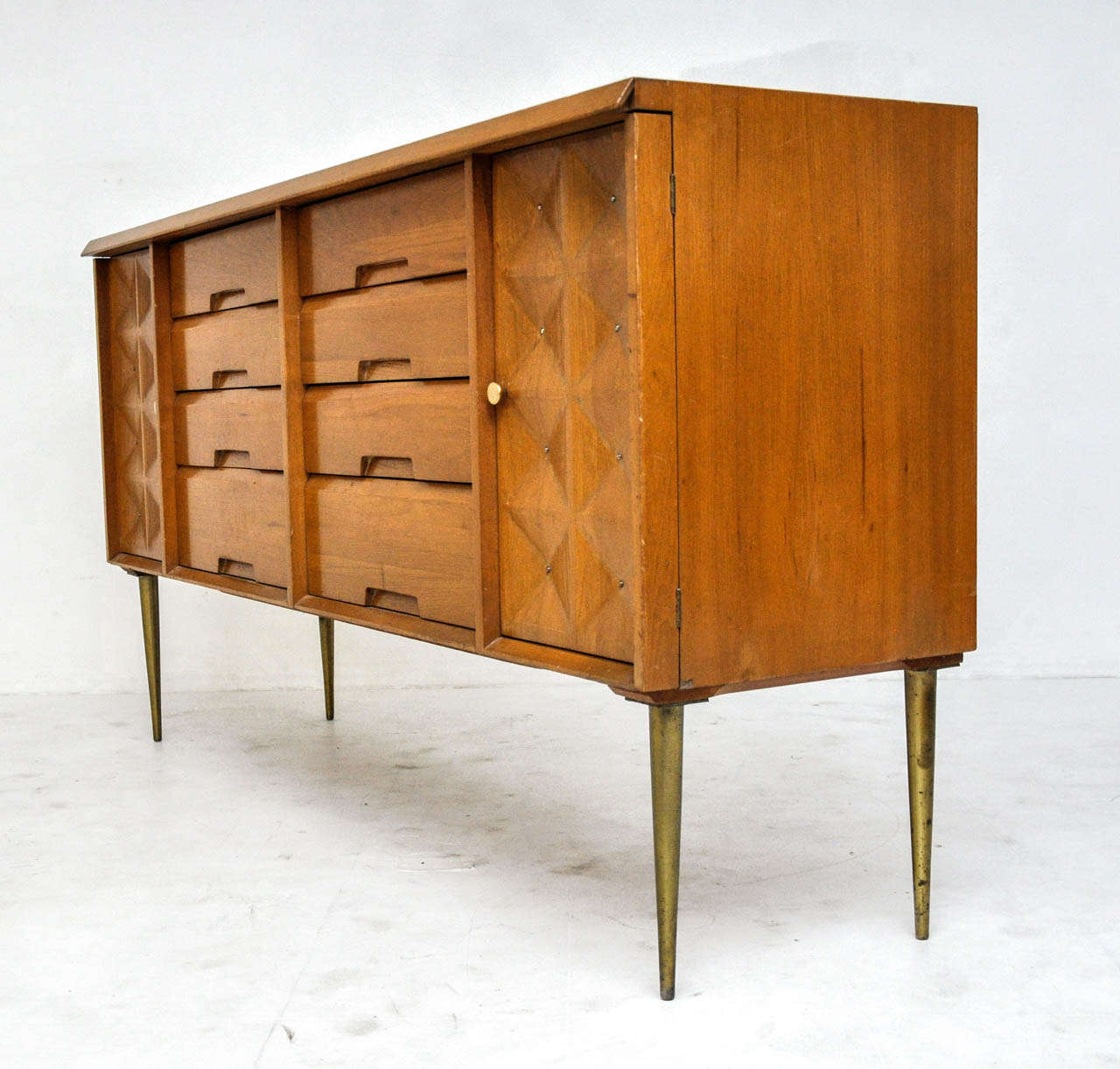 Birch sideboard by Salvatore Bevelacqua for Alliance Furniture, circa 1954. Sculpted door fronts with brass details and brass legs.

Matching highboy dresser available.