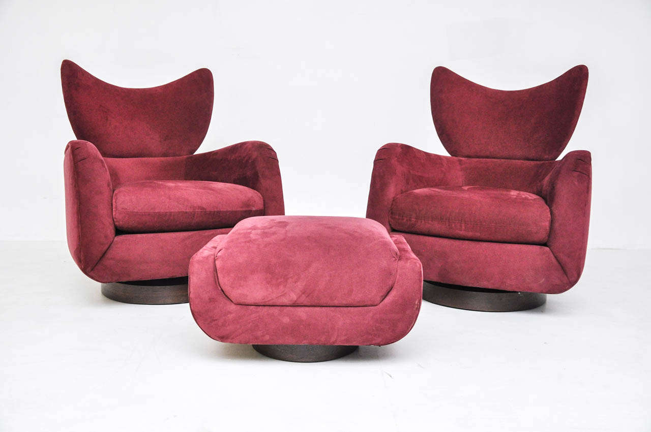 Pair of swivel lounge chairs with single ottoman. Designed by Vladimir Kagan for Directional. Original upholstery with walnut bases. Chairs swivel and rock.