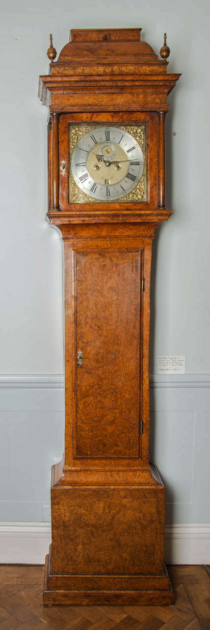 A George II period, antique eight day longcase clock of smaller size with unusual burr-yew case.

The moulded case is veneered with warm colored burr-yew and has a rectangular trunk door. The crossbanded base panel is supported by a double-stepped