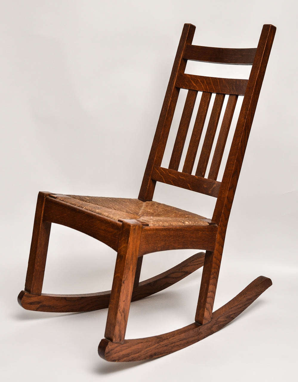 Mission Oak Rocking Chair designed by the Michigan Chair Company.  Small scale with original rush seat. Good patina (original warm oak)
