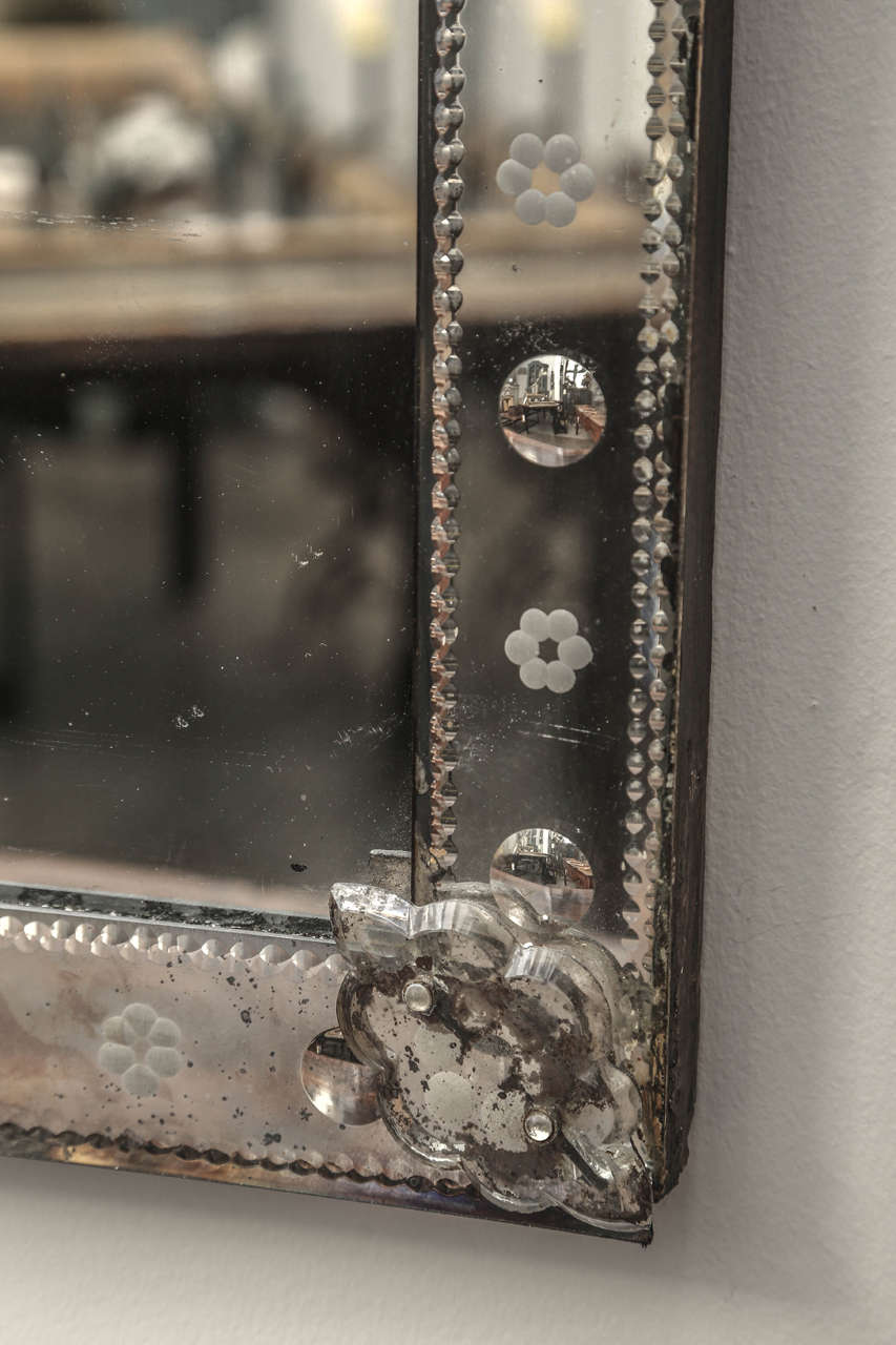 19th century Venetian mirror with intricate detailing on border. Border has cut glass so that etching is reflected on back glass and appears as a double row of etching on both sides. Border center has bubbles and flower etchings. Beautiful detail