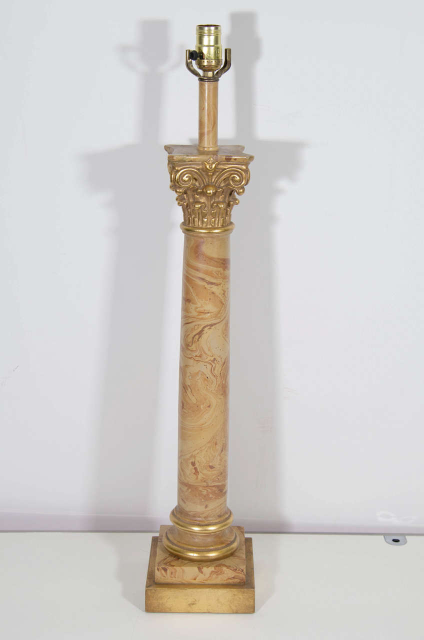 A vintage pair of Chapman column lamps decorated in faux marble with a gilded capital and base. Good vintage condition with age appropriate wear and patina. Some cracking along with nicks and scratches.