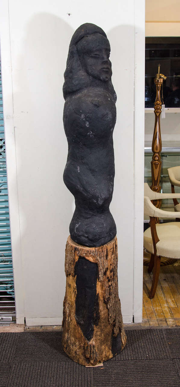 A vintage black sculpted limestone concrete fertility sculpture on a tree trunk base, circa 1960s. Good vintage condition with age appropriate wear.