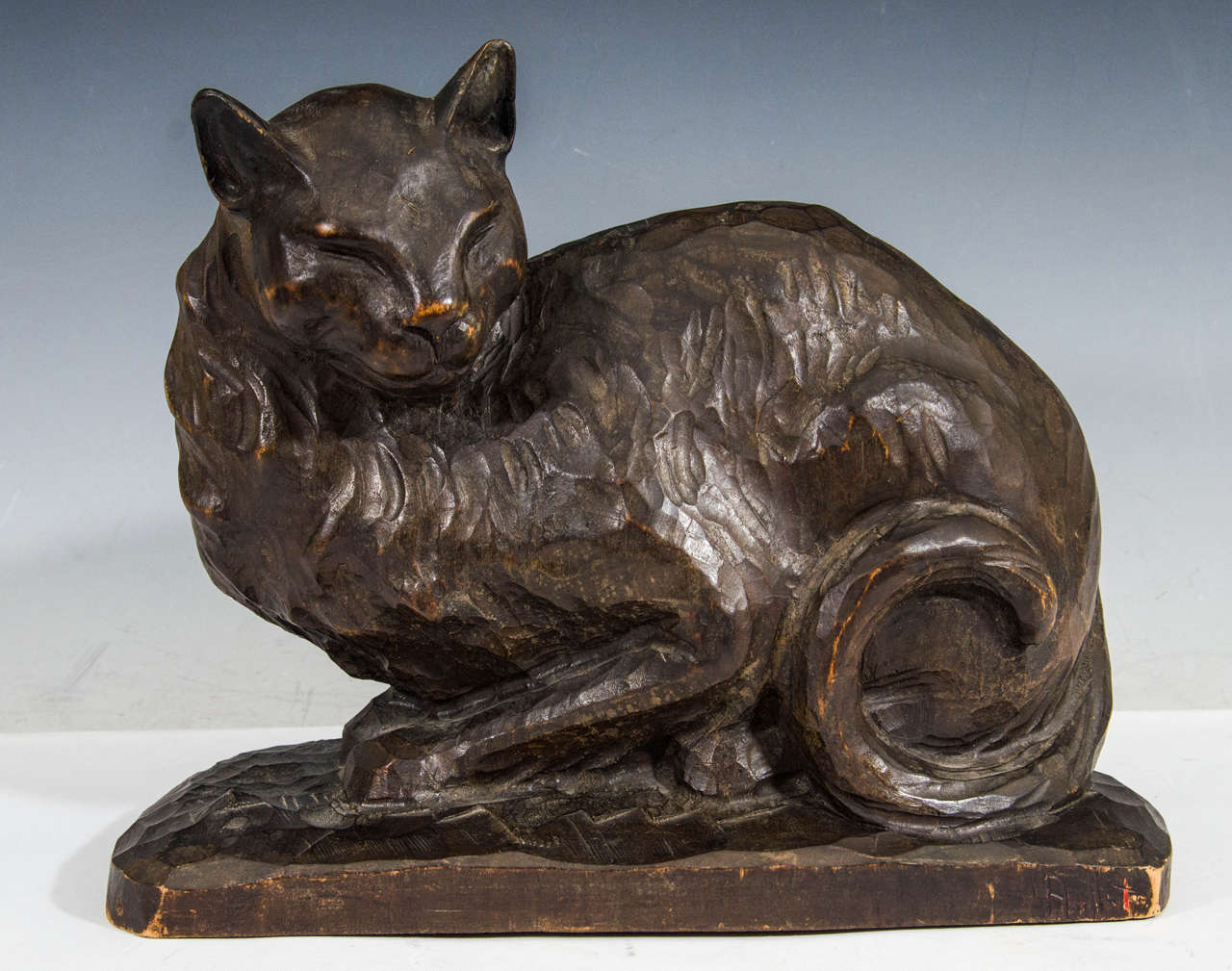 A superb wood carving by a master sculptor of an enchanting cat. Illegibly signed. Initials may be AHT. Good condition with age appropriate wear. Some nicks to the wood.