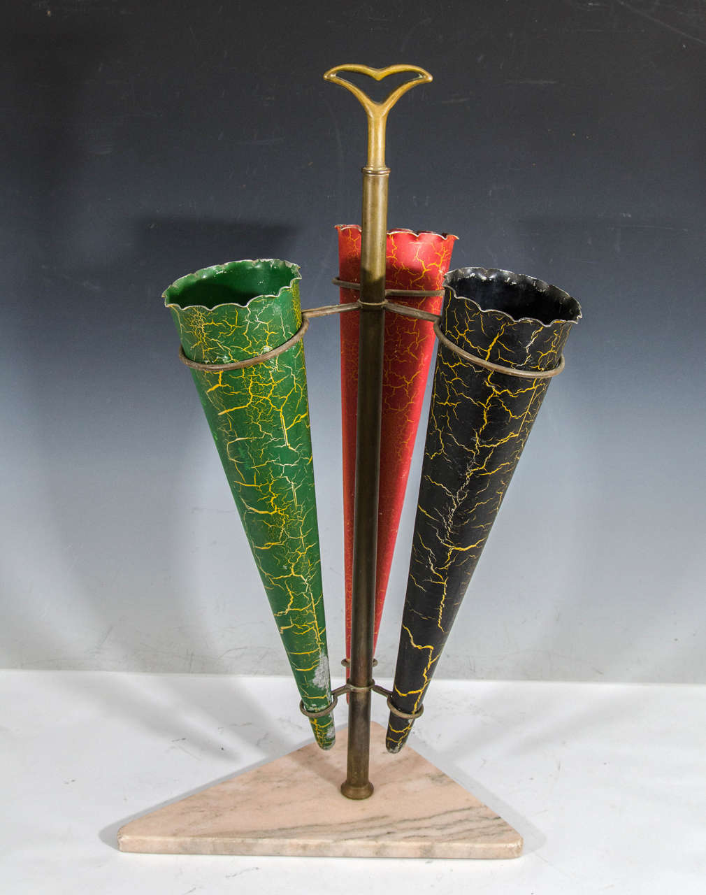 A vintage brass umbrella stand with marbleized red, green and enamel cones attributed to Fontana Arte. Good vintage condition with age appropriate wear. Slight loss of finish where cone sits inside base.