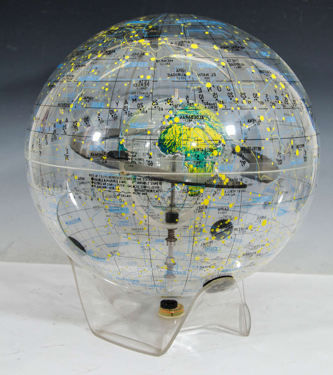 A vintage transparent celestial globe with internal terrestrial globe made of plexiglass with a modern base and built-in compass. The globe is dated 1977 and was produced by Robert Farquhar of Philadelphia, PA.
