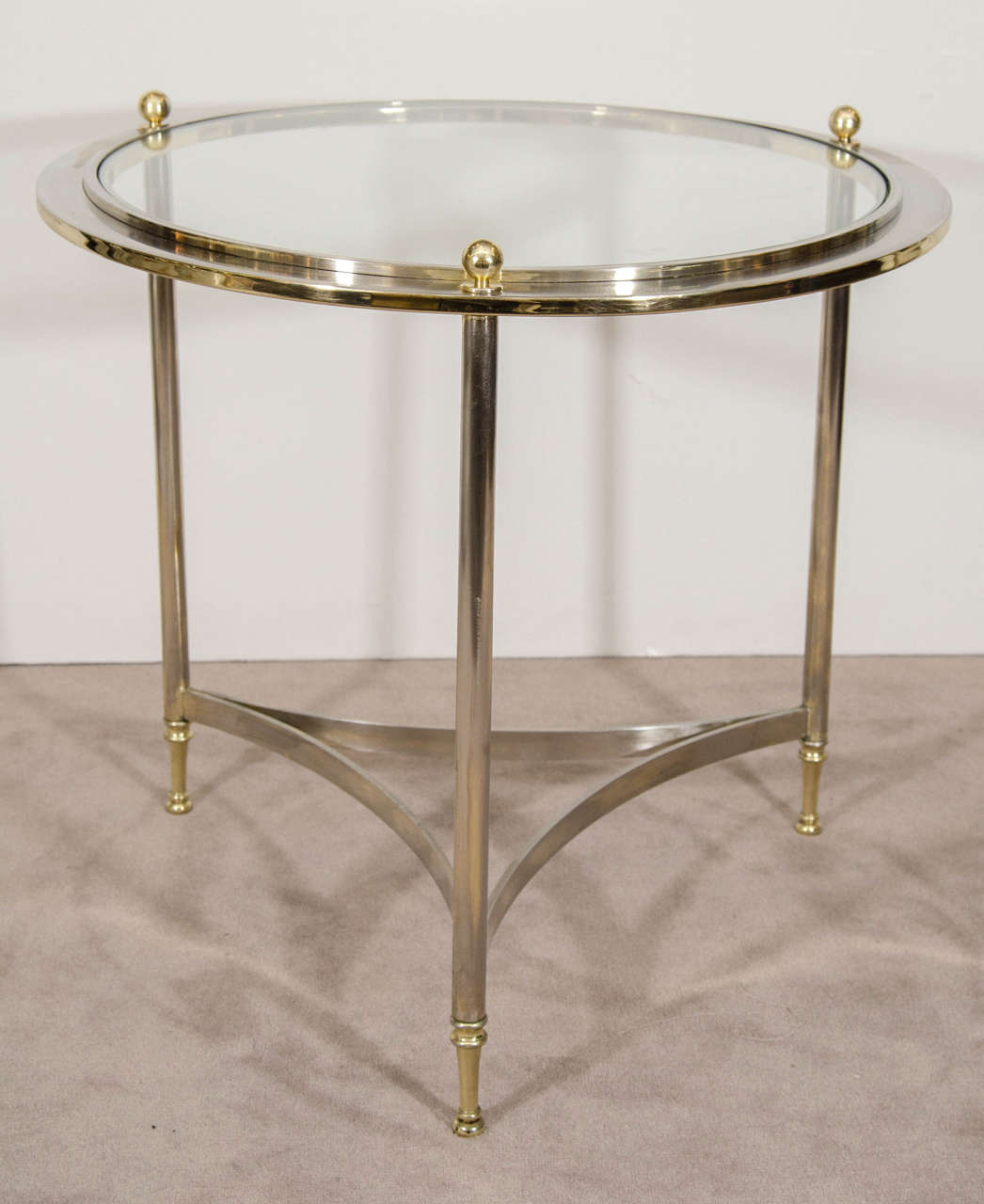 A vintage circular steel table with brass accents and glass top by DIA, Design Institute of America. Good vintage condition with age appropriate wear and patina. A few minor scratches.