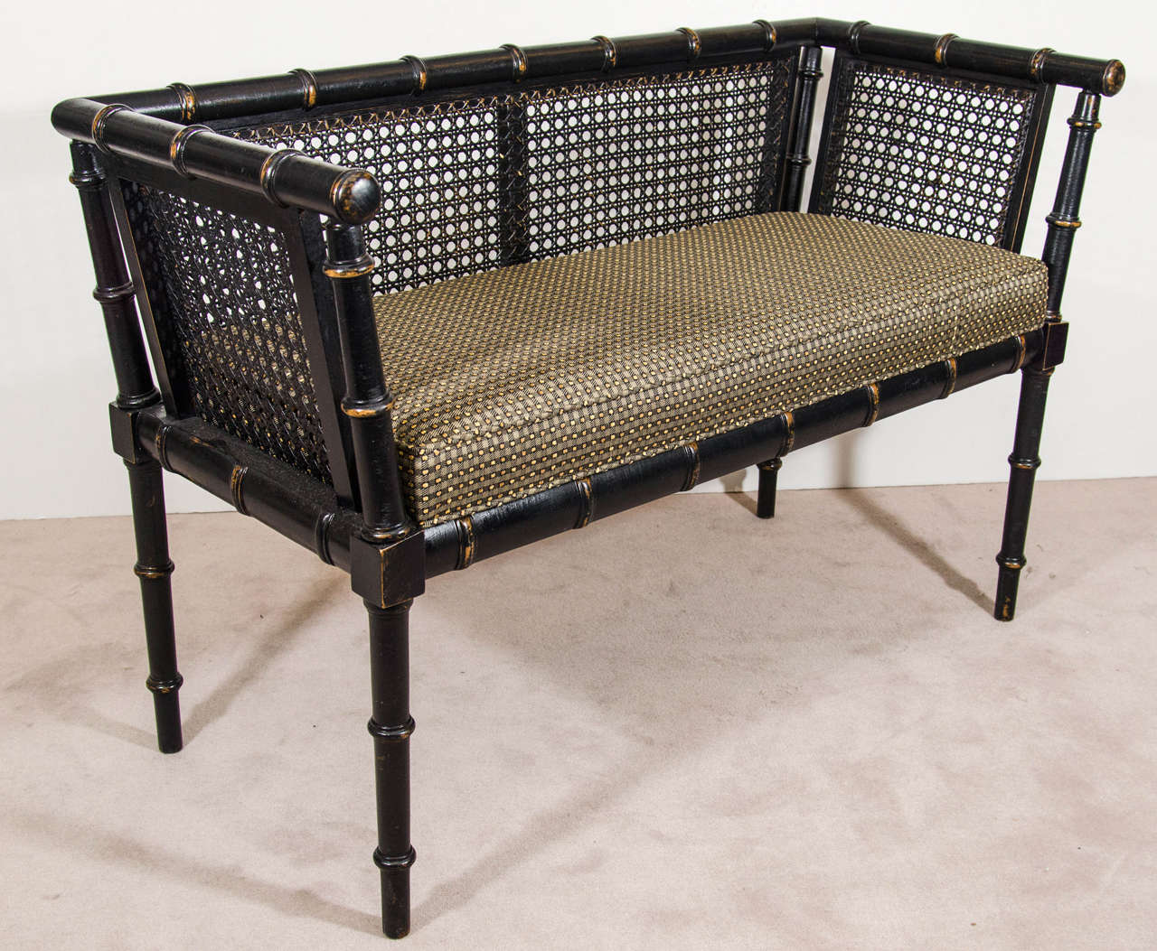 A vintage 1960s faux bamboo bench with caned back and sides and original black finish. Newly reupholstered.