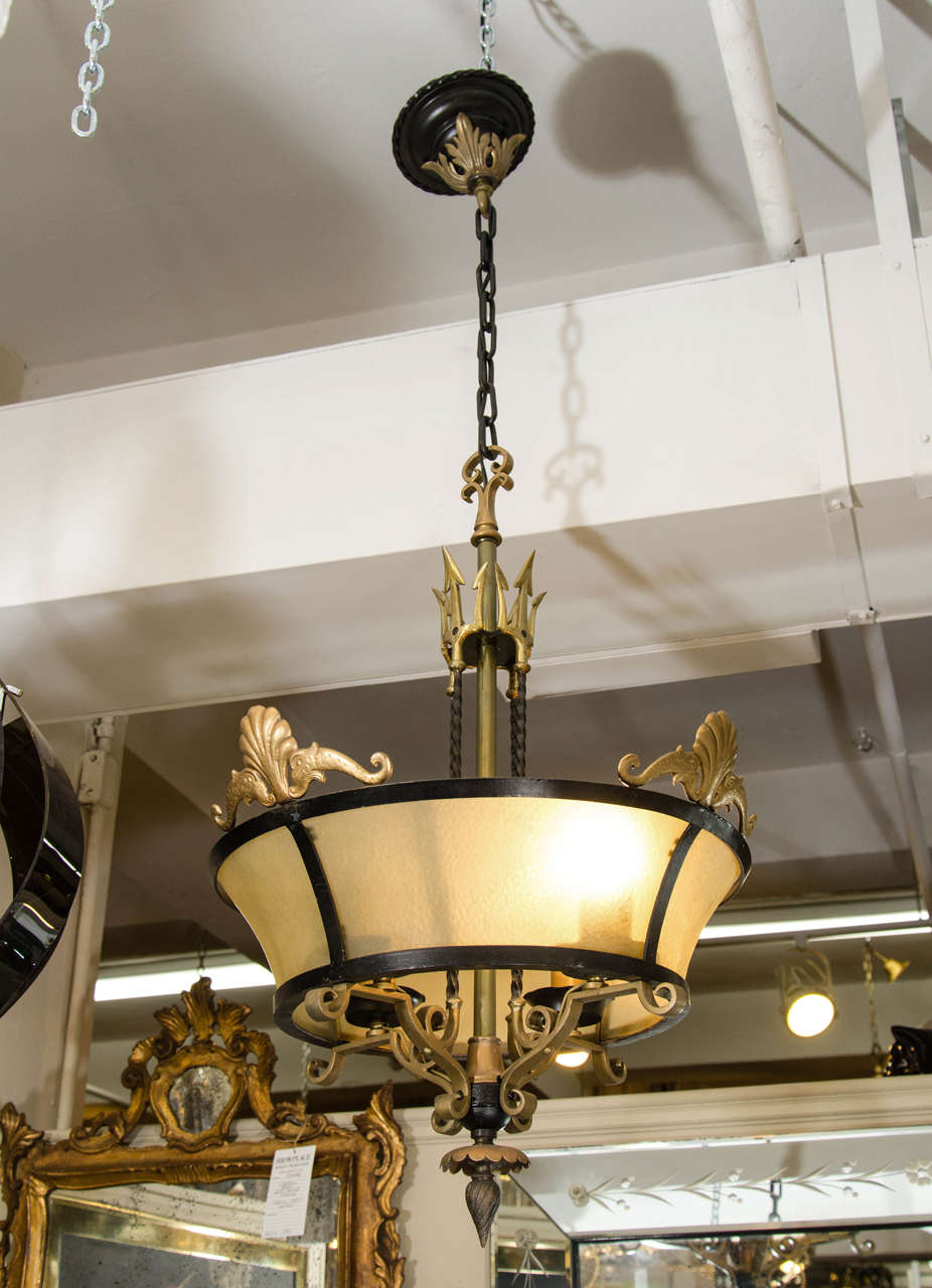 A substantial vintage brass, gold frosted glass, and black iron chandelier with pitchfork details in the style of Tommi Parzinger, circa 1960s. 

Measurements:
22 in. Diameter
48 in. H including chain
30.5 in. H to top of fixture

