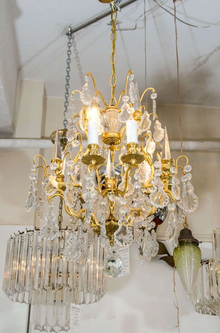 This beautiful crystal chandelier has a gold gilded frame with crystals and crystal spikes (see image #10.) Chandelier has six-lights/arms, a crystal center design and crystal ball drop finial, as shown in image #9. Longest crystal measures 5