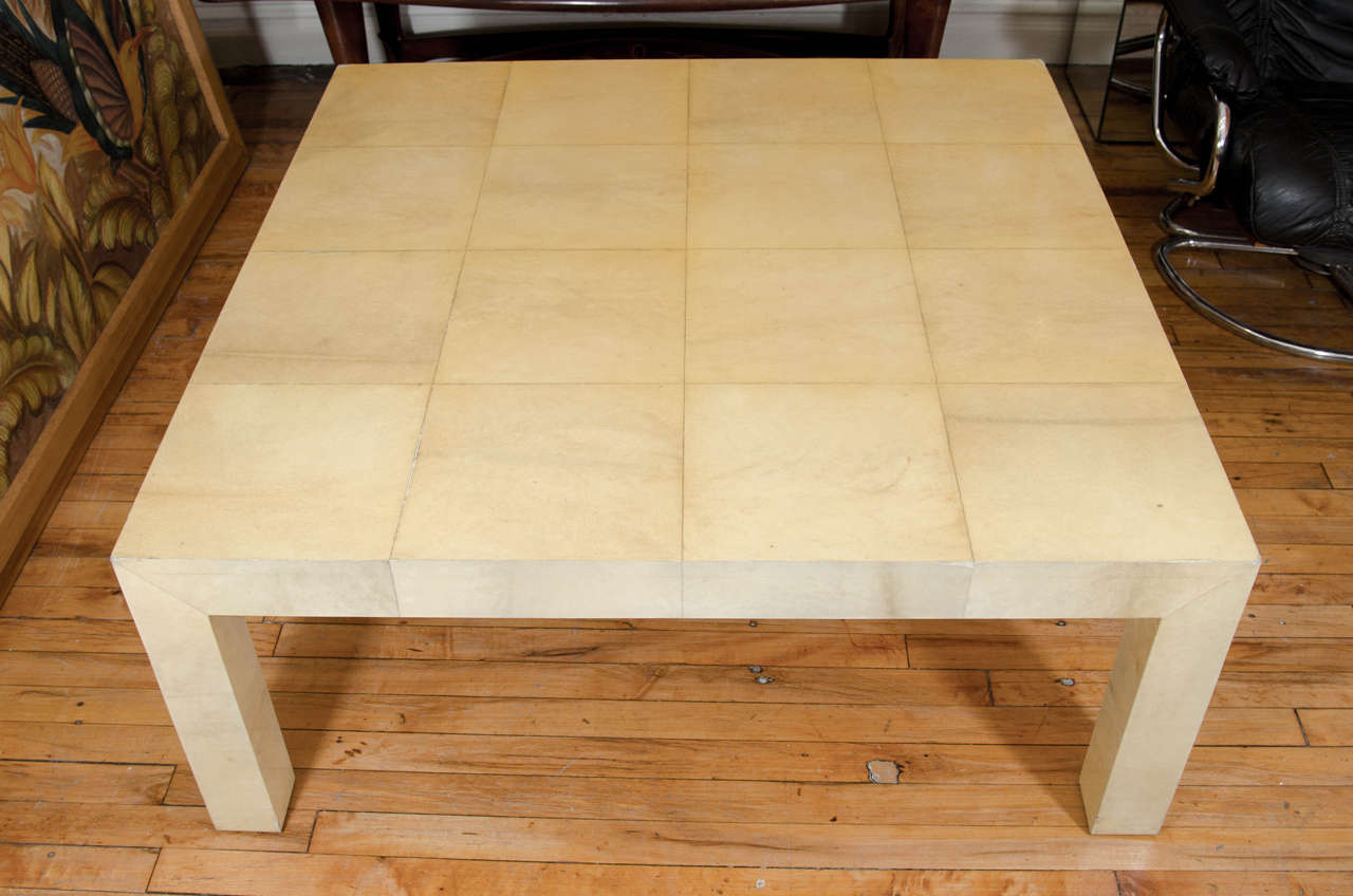 A vintage Karl Springer inspired substantial goatskin parchment coffee table or cocktail table. Good vintage condition with age appropriate wear especially around the top edges. There are some scratches and scuff marks, along with a few areas of