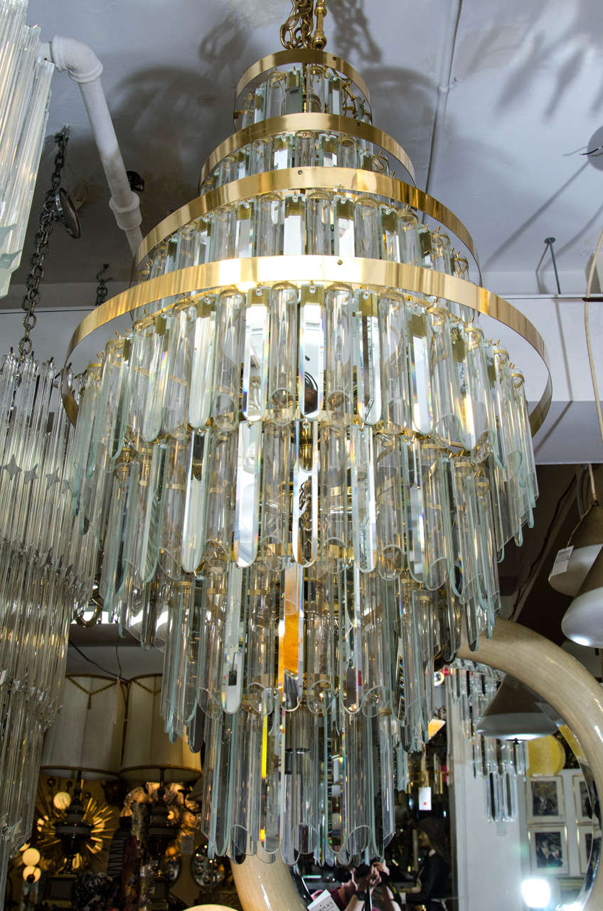 A vintage chandelier with seven tiers of alternating mirrored crystals and tubular glass on a brass frame.    Good vintage condition with age appropriate wear and patina.  Four missing glass tubes. 