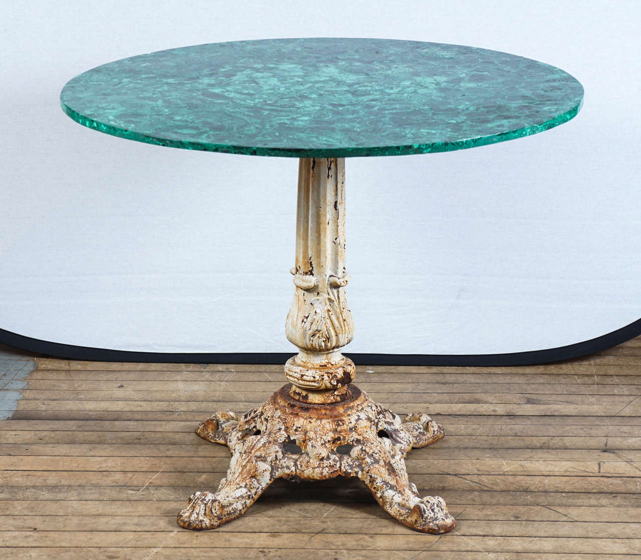 Large half inch malachite tabletop married to a 19th century cast iron base in crusty painted surface.