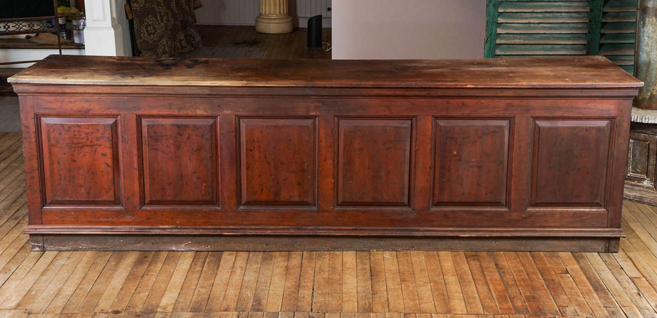 Country counter, two board cherry top, pine base, six raised panels across the front, one on each end, till drawer, dry red wash surface, beautiful untouched worn patina.