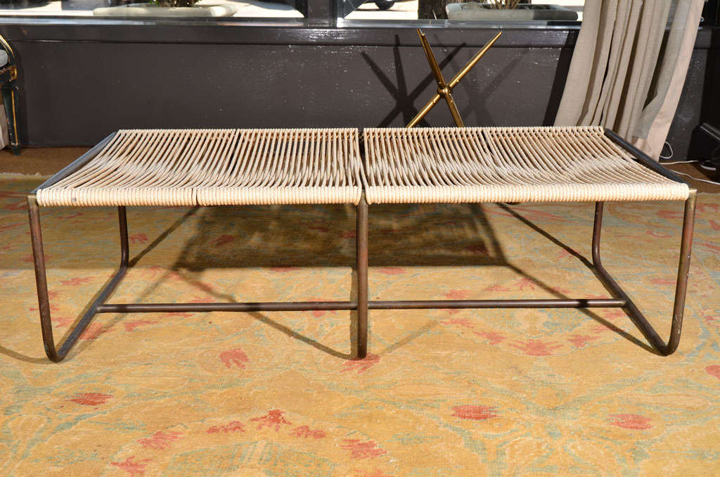 a bench by Walter Lamb, three shaped brass supports / legs with stretcher that runs the length of the piece, rope seat