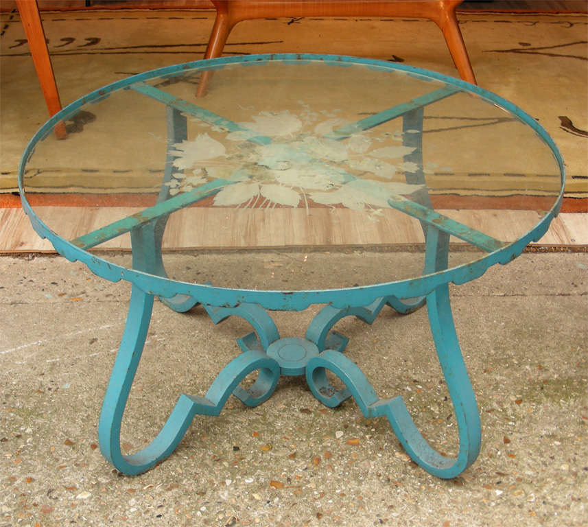1950s coffee table with metal base and eglomisé glass top.