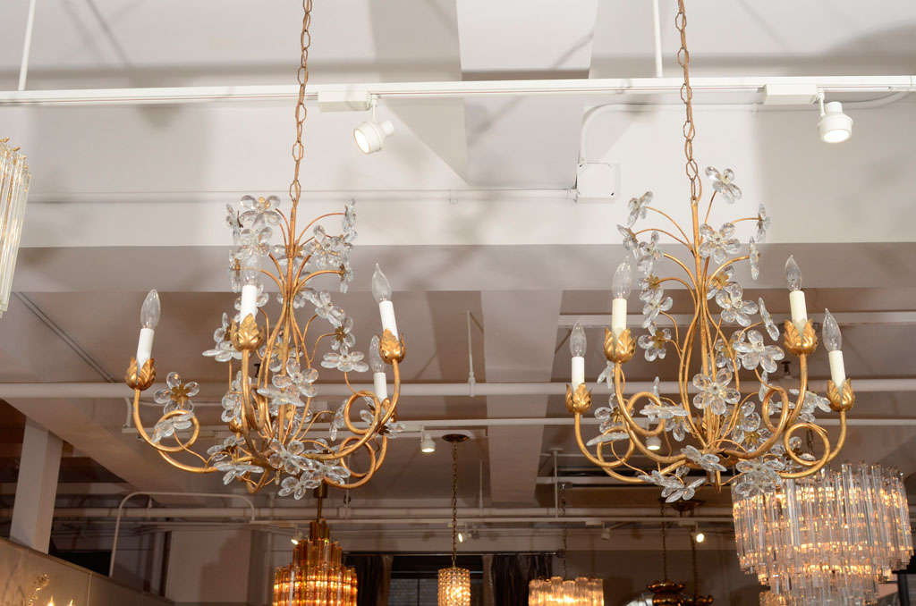 A charming pair of  five-arm gilt metal chandeliers with lovely leaf bobeches and crystal flower accents.