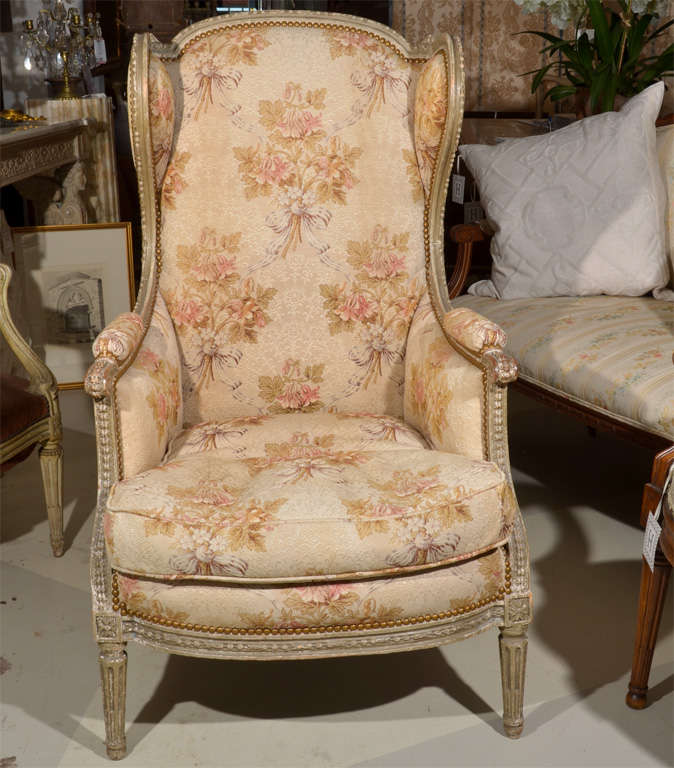 Louis XVI Style Wingback Armchair,
curved crest over the upholstered arms, back and seat, raised on fluted tapering legs.