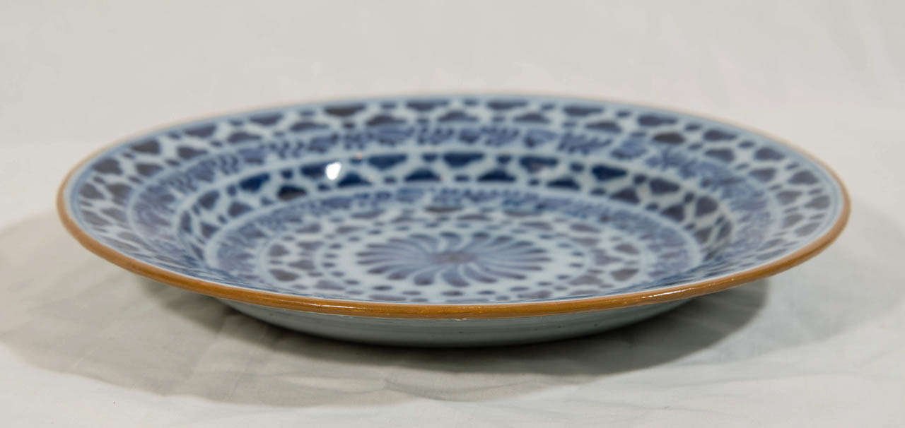 A pair of Dutch Delft Blue and White dishes with a geometric pattern of concentric circles with alternating bands of scrolling vines and clouds
all encircling a pinwheel.