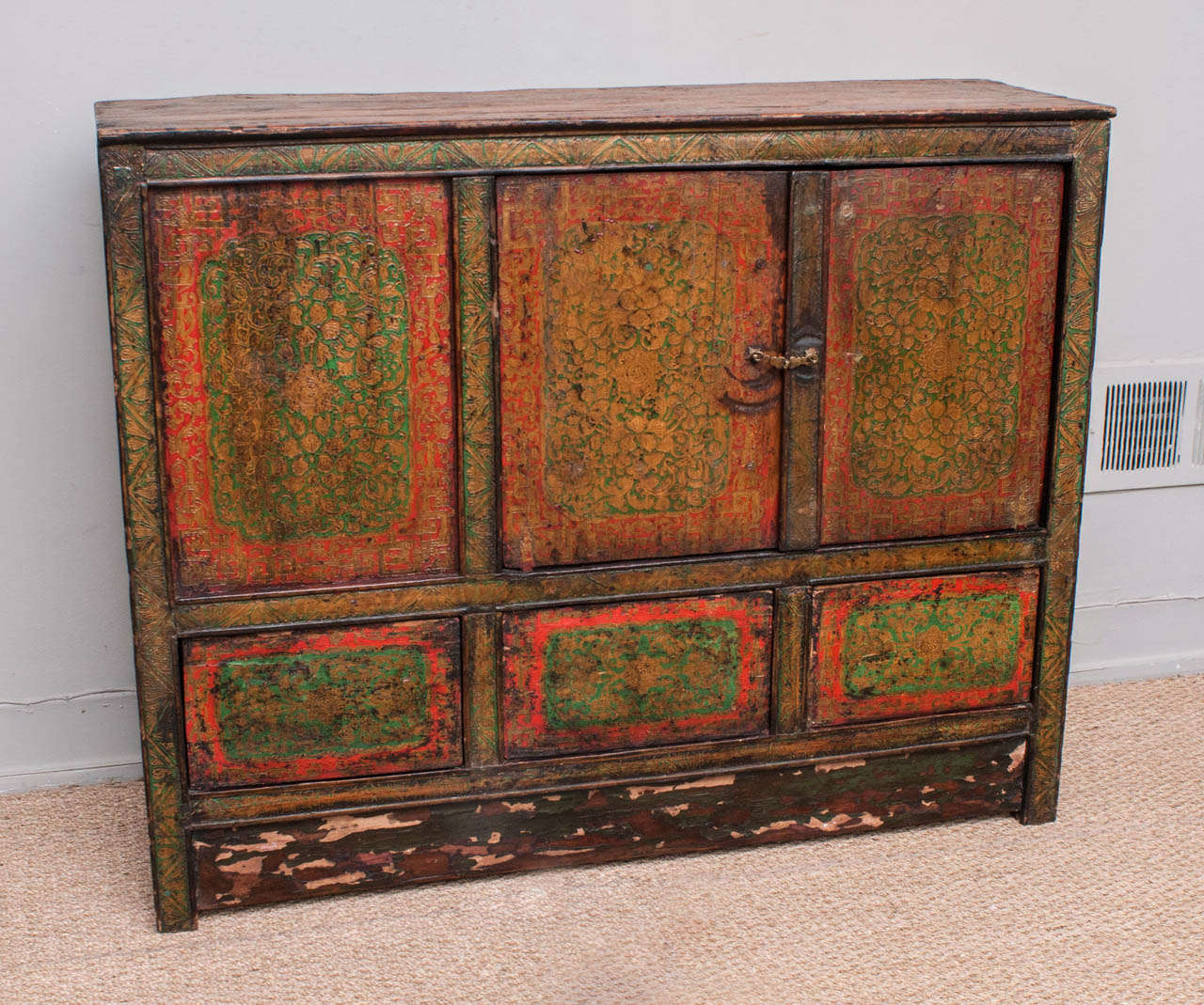 Hand painted and handcrafted Tibetan cabinet with original red and green paint with traces of gold. This cabinet has a two door opening with interior shelf, plus three 