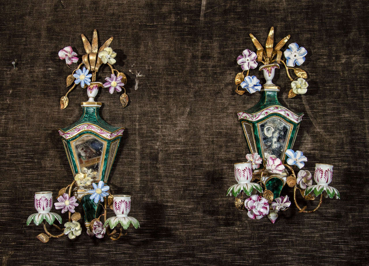 A pair of rare antique French Louis XVI gilt bronze, hand painted porcelain and mirrored wall sconces of great detail embellished with mirrored backs and further adorned with fine hand painted polychrome enameled multi-color porcelain flowers.