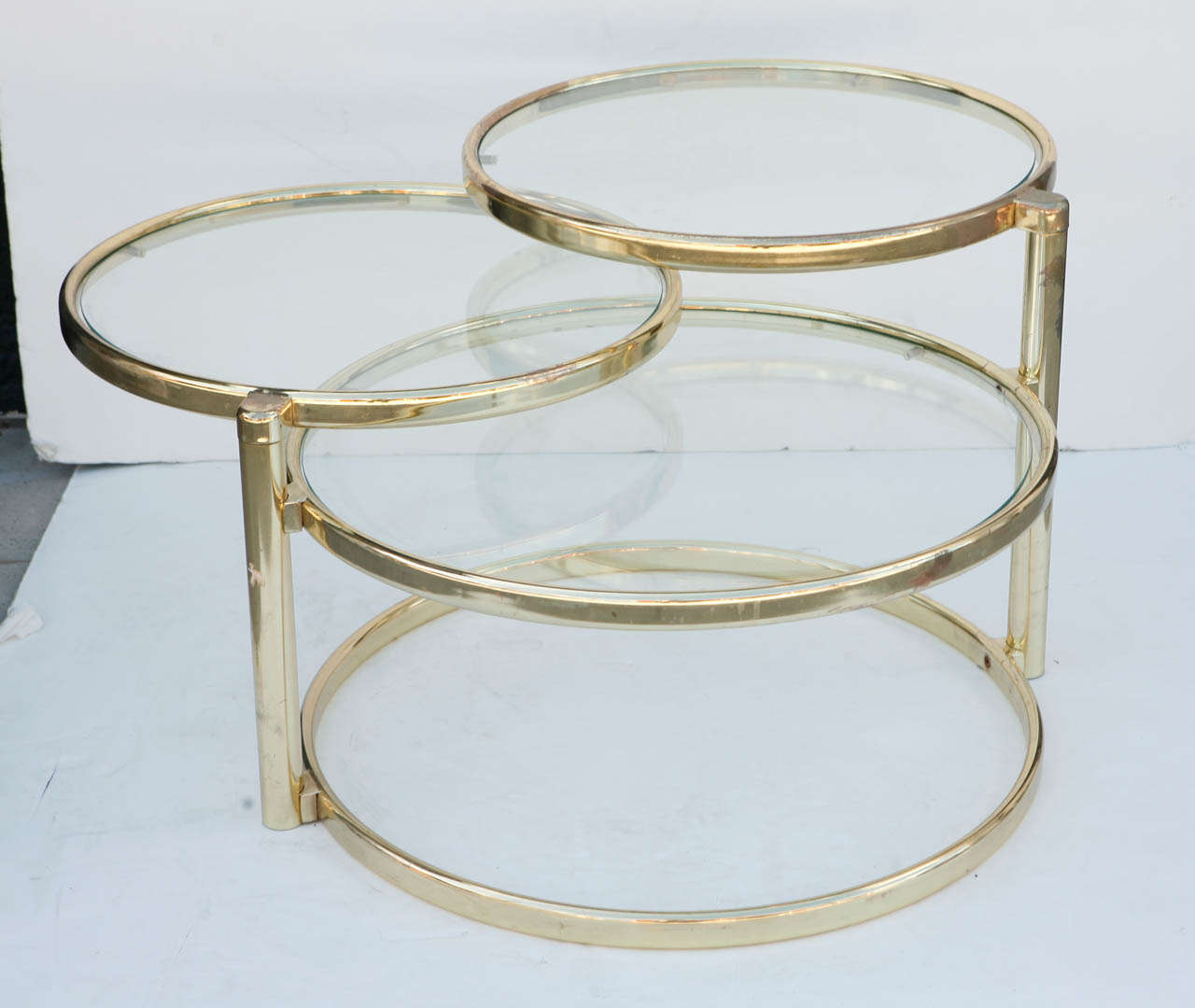 3 Tier 1970's brass and glass swivel coffee table.  Both top tier and middle tier swivel out to expand the length of the table to 65