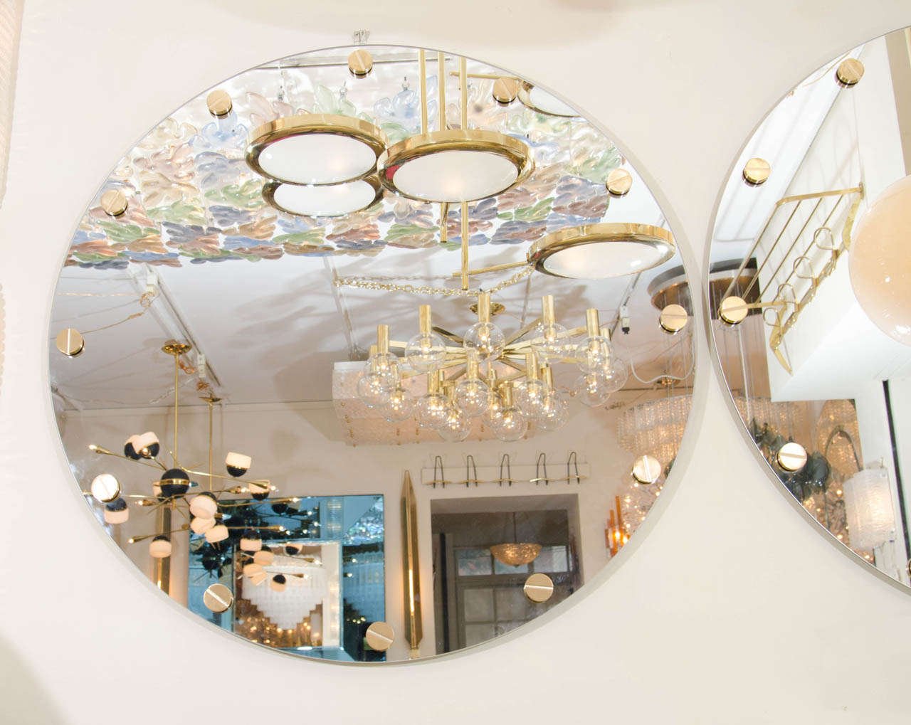 Circular mirror with applied brass stud detail.