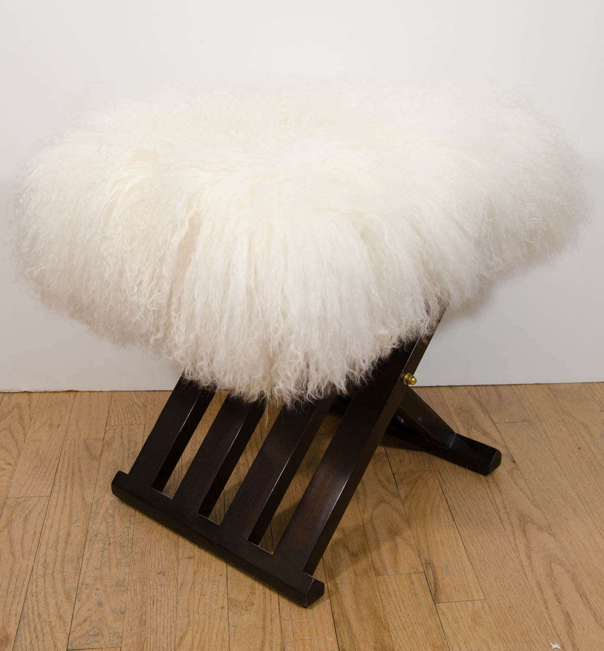 Pair of lacquered wood campaign style benches with upholstered shearling cushions and brass details by Harvey Probber.