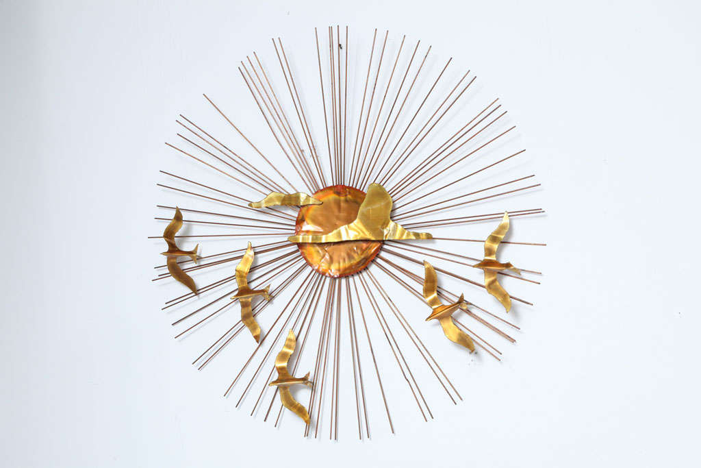 Sunburst wall sculpture made with brass, in the manner of C.Jere. A depiction of a flock of birds flying across the sun. The sun and the birds are made of thin sheet metal (brass and copper it looks like)and the rays are thin rods.