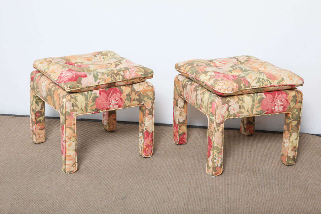 Pair of beautiful square ottomans. Covered in a floral pattern fabric. The cushioned top makes them extremely comfortable.  Perfect for any room that needs a dash of color.