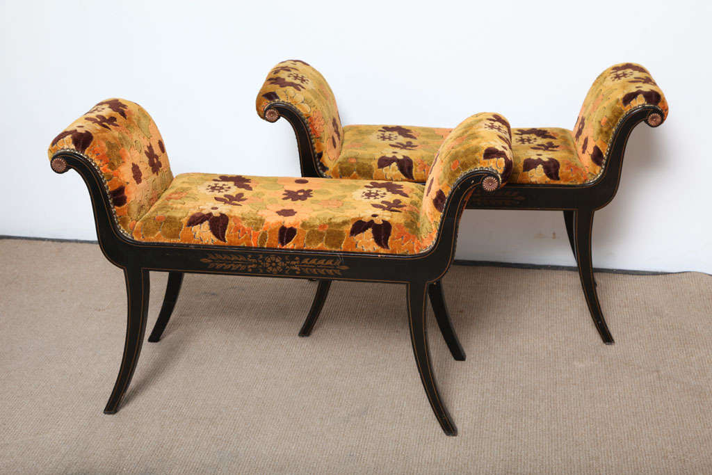 Pair of beautiful Empire style benches. Black lacquered with pinstriping, accents and decorational art in gold. The 70'S fabric is a very bright velvet floral design which really contrasts the darker base.