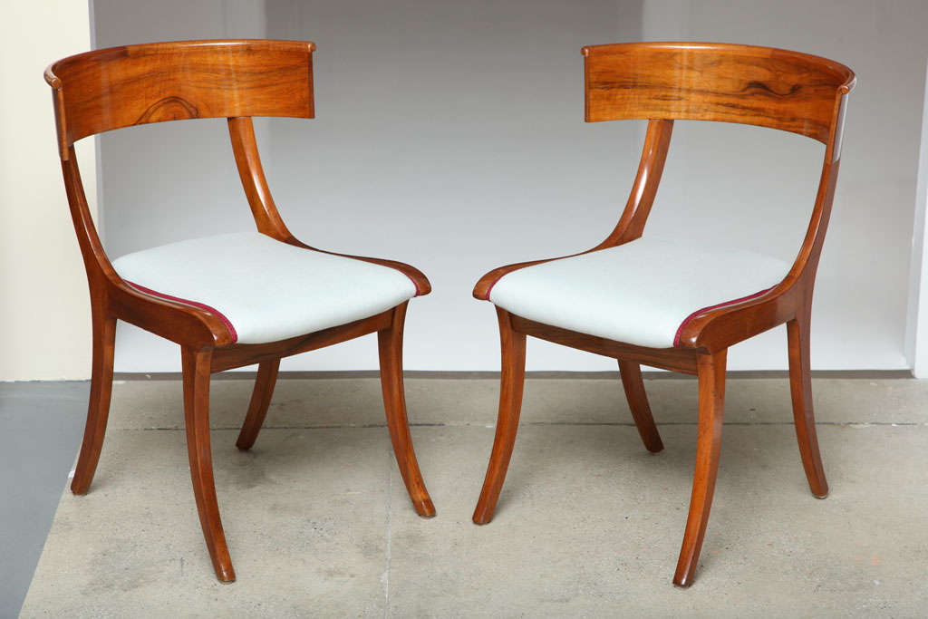 A pair of Danish walnut Klismos chairs, Circa 1860, of classic form, upholstered seat and sabre legs.