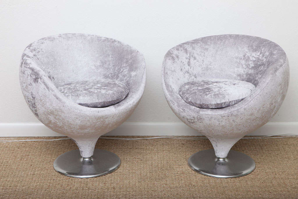 Pair of rounded swivel chairs with aluminum bases and finished in silver velvet. These conversation chairs are from the Mod Movement and have stood the test of time---they are as chic today as when they were originally designed and add modern
