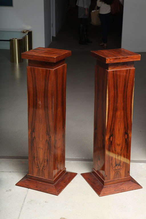 A pair of 1940s Art Deco Style rosewood display pedestals in classic column form finished in a rich rosewood with display tops measuring 11 in. x 11 in. Pair is in excellent condition.