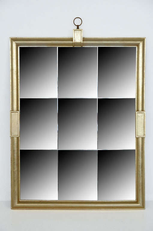 Opulent mirror by Tommi Parzinger.  Gilt wood frame with lattice mirror and brass finial.
