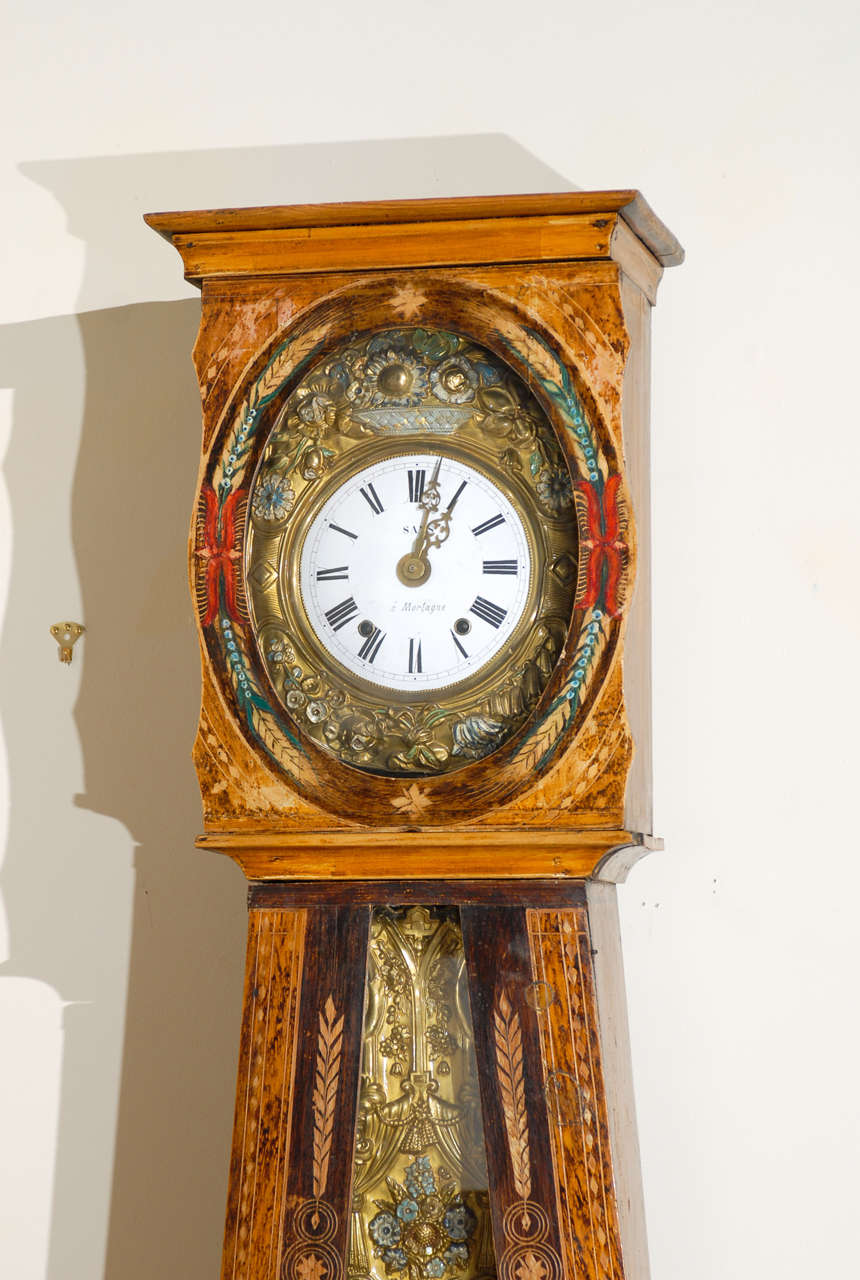 This is a beautiful clock with painted details depicting wheat and flower motifs.  The wood is also very pretty.  The flower and wheat designs continue on the clock workings.  The clock is from  southern France.