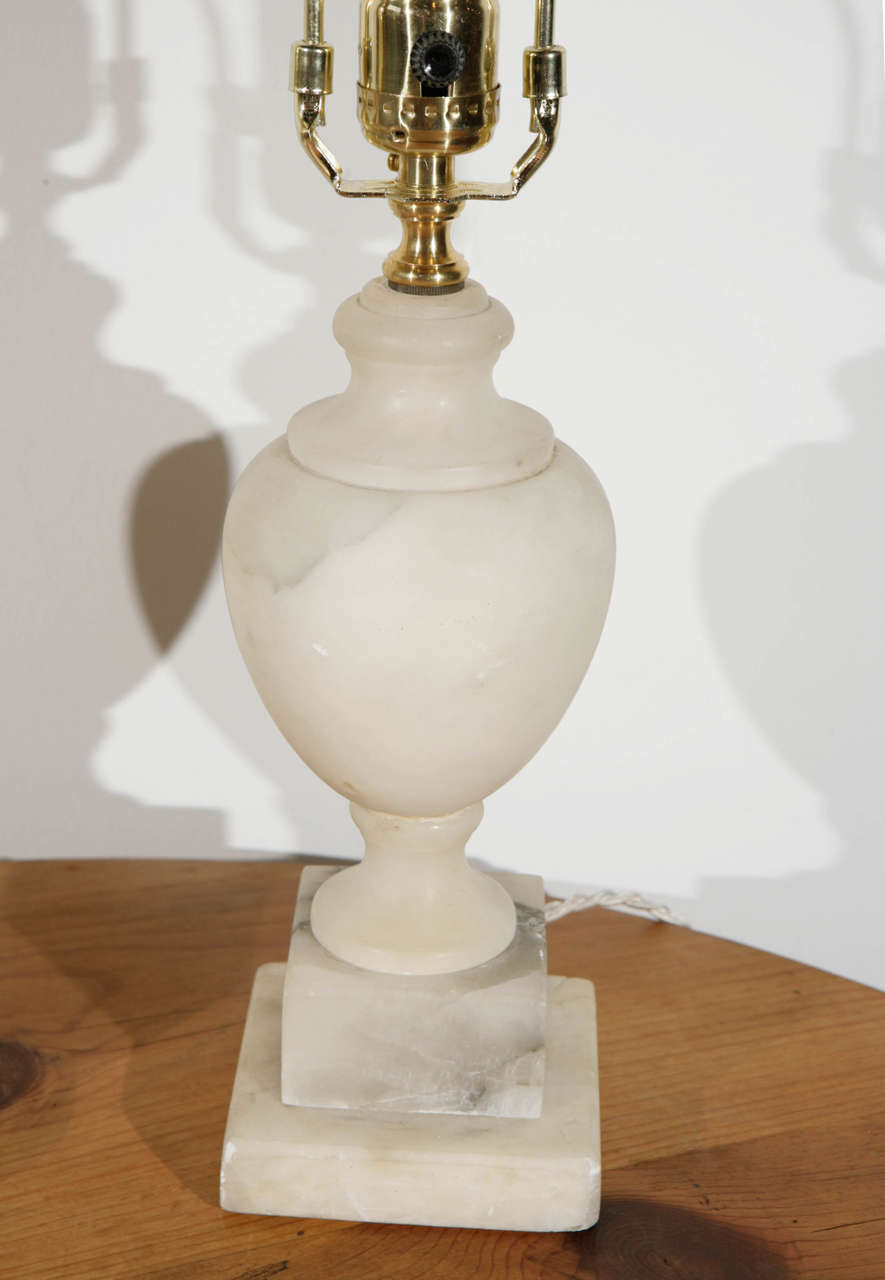 The simple neoclassical silhouette of these table lamps are perfect for a bedroom or buffet. Newly rewired.