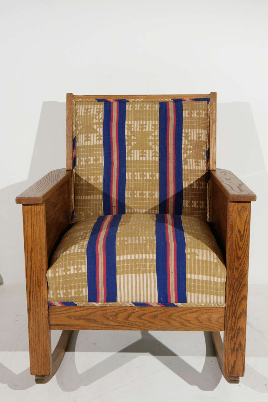 Turn of the century quaint yet strong antique rocking chair. Newly upholstered in a soft striped cotton.