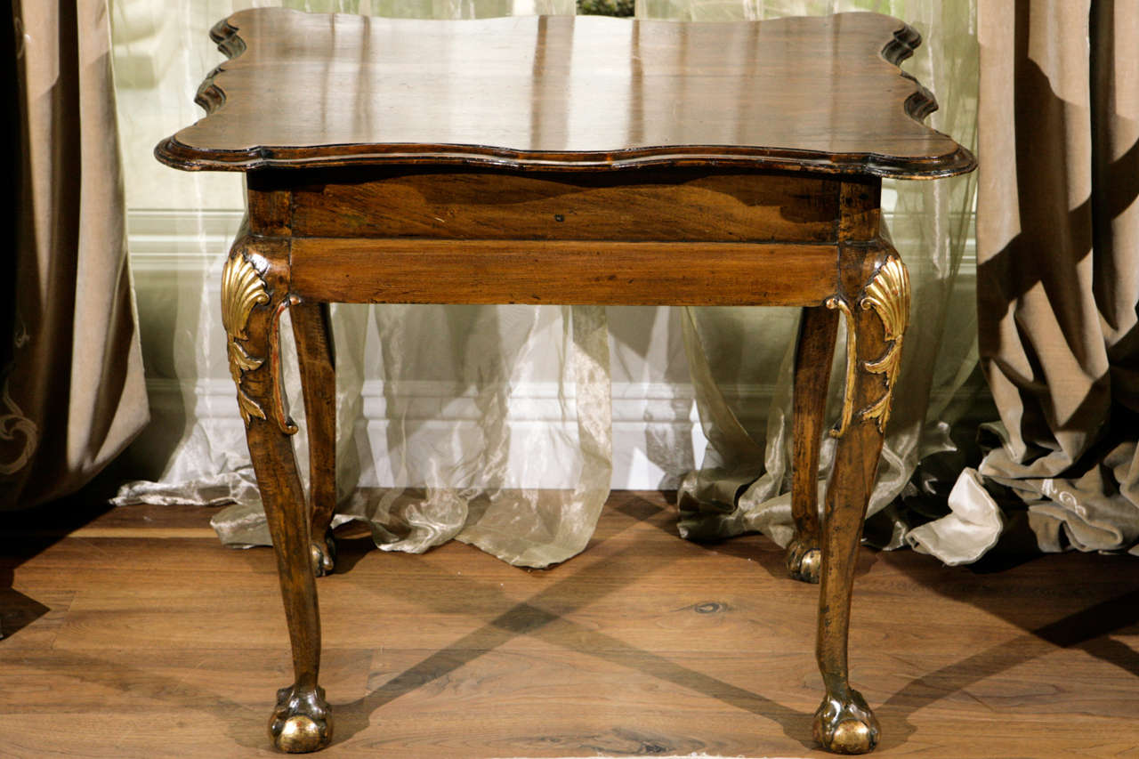 XVIIIe siècle Table d'appoint en noyer irlandais avec pieds billes et griffes.  La table est ornée d'accents en bois doré et d'un motif de coquillage.