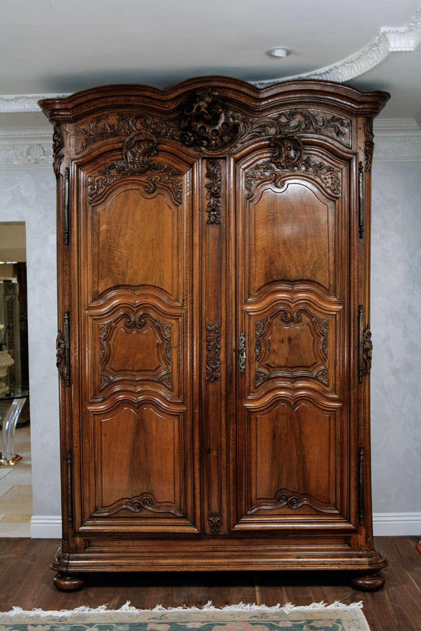 Early 18th century Period Regence French Finely Carved Walnut Oversized Armoire with Bun Feet.  Original Key is included.