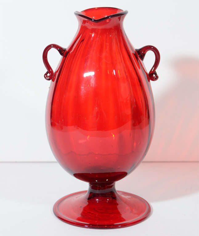 A brilliant red vase with two applied handles.