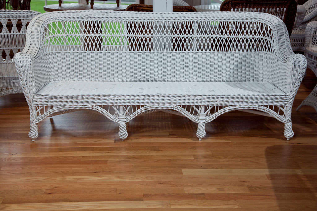 Bar harbor wicker sofa with woven seat and feet.

Measures: Width 82", seat width 73.5", off the wall depth 32", seat depth 24", height 34.75".