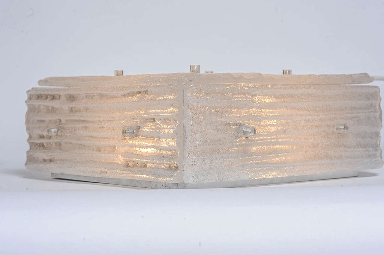 Very large 33.5 cm square ceiling light made by Austrian manufacturer Kalmar, designed in the early 1960s.
Made of 5 structured ice glass panels on a steel structure containing 4-light bulbs. It has a very warm radiation of light.